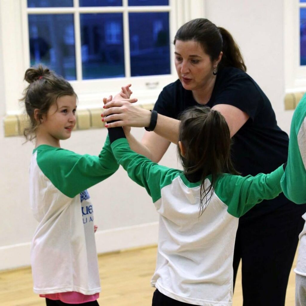 Bluegrass Ceili Academy's Megan Moloney works with two young dancers. 

