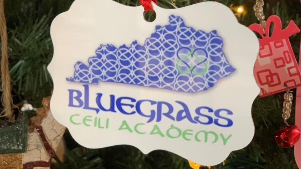 A holiday ornament with the state of Kentucky and the Bluegrass Ceili Academy logo