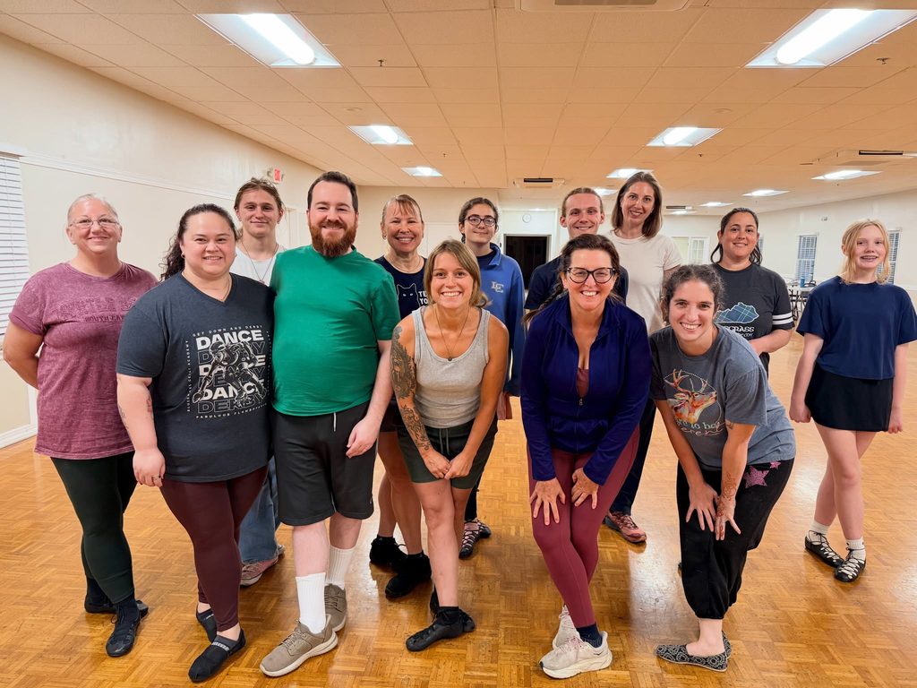 A group of adult and teen students posing together during Monday Irish dance classes in Lexington, KY with Bluegrass Ceili Academy class.
